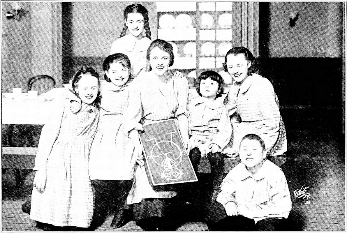 The children are gathered around the drawing of the Trustee